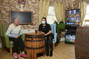 Activities Manager Natasha Evans enjoys a drink and a chat with one of the residents at Meddyg Care home Porthmadog in their new pub
